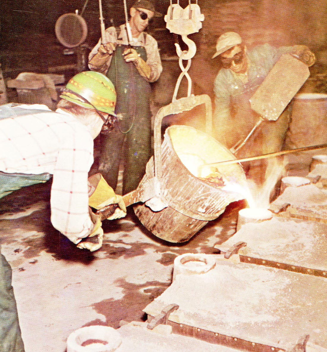 Foundry workers pouring molten metal